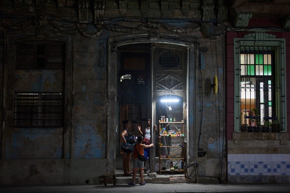 KEYPIX - A vendor speaks with customers in the doorway of his building in Havana, Thursday, March 5, 2026. (KEYSTONE/AP Photo/Ramon Espinosa)