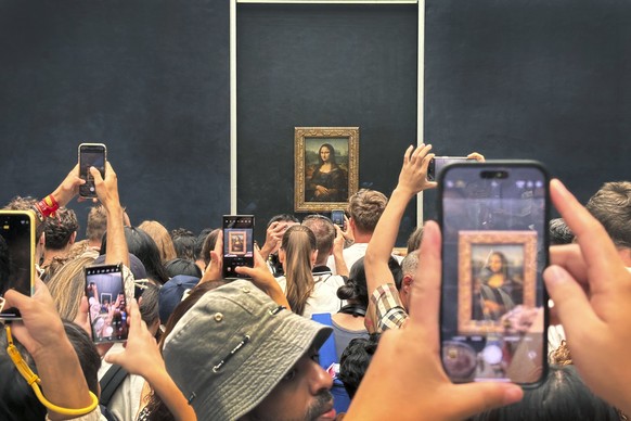 Tourists jostle each other to see and take a photograph of Leonardo da Vinci&#039;s painting of the Mona Lisa at the Louvre Museum in Paris, France, Wednesday, Aug. 8, 2024. The Mona Lisa painting at  ...