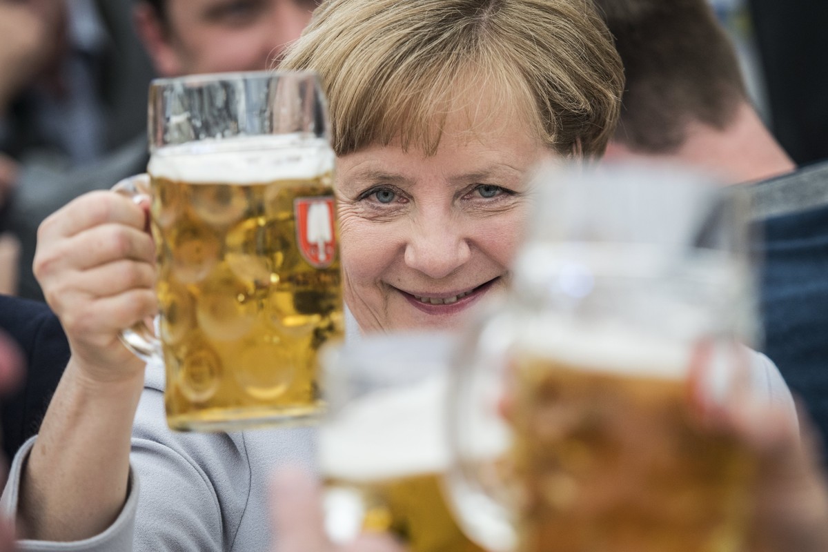 epa05995406 Germany's Christian Democratic Union (CDU) party chairwoman and German Chancellor Angela Merkel toasts with a beer during an election campaign event of the German Christian Social Uni ...