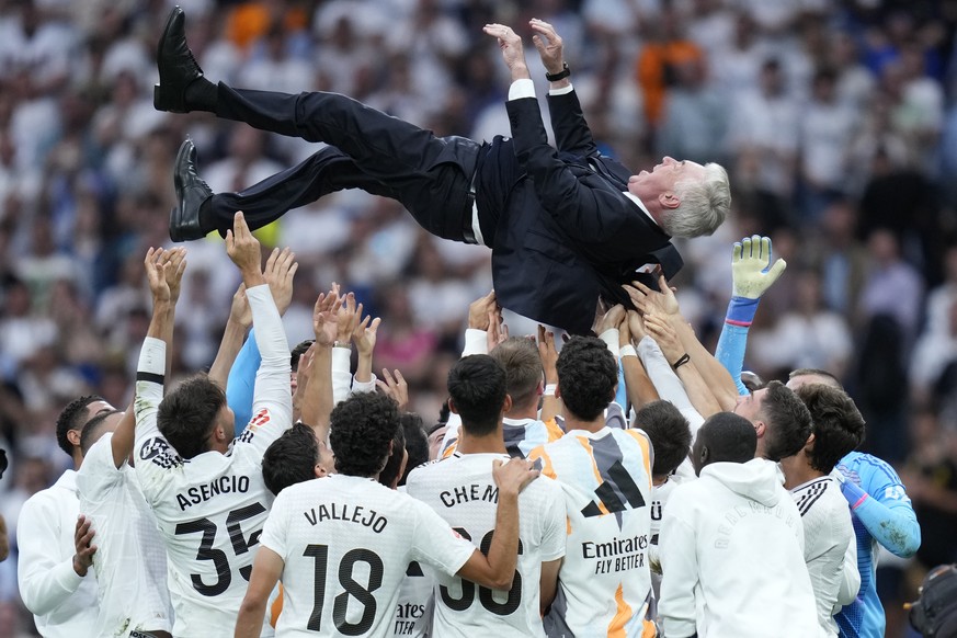 Real Madrid's head coach Carlo Ancelotti is tossed into the air by his players after defeating Real Sociedad at the end of a Spanish La Liga soccer match, at Santiago Bernabeu stadium in Madrid,  ...