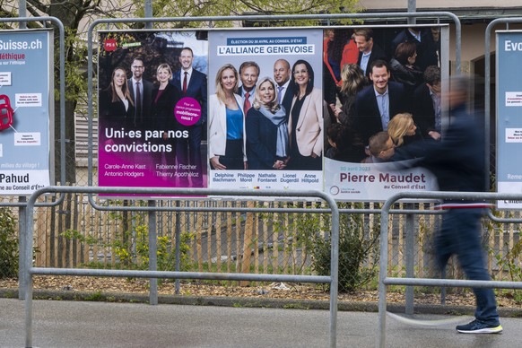 Une personne passe devant les affiches electorales du deuxieme tour de l&#039;election du Conseil d&#039;Etat, l&#039;affiche du parti Socialiste et les Verts avec les candidats, Carole-Anne Kast, Ant ...