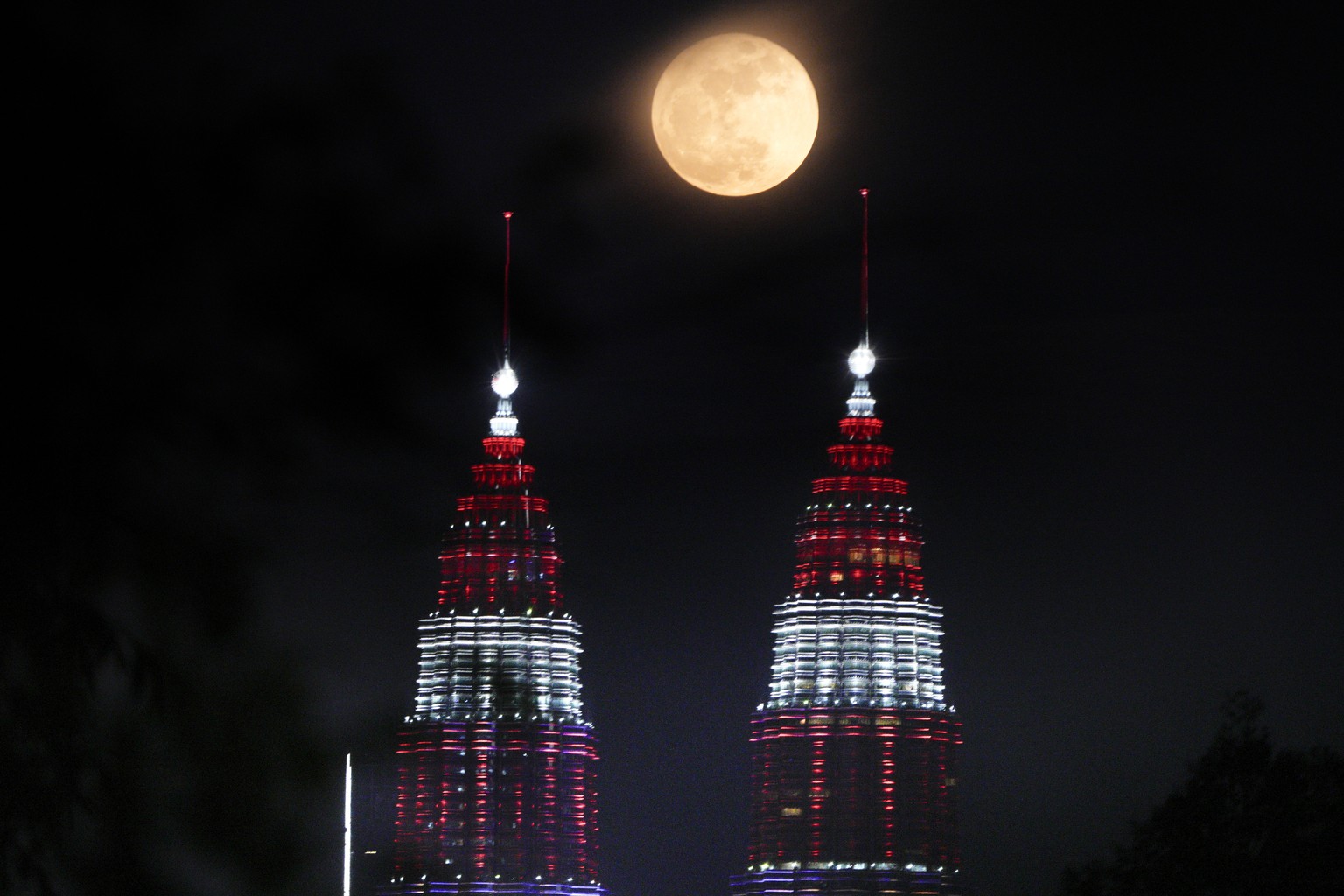 A supermoon rises over Petronas Twin Towers in Kuala Lumpur, Malaysia Thursday, Aug. 31, 2023. The cosmic curtain rose with the second full moon of the month, also known as a blue moon. A little bigge ...