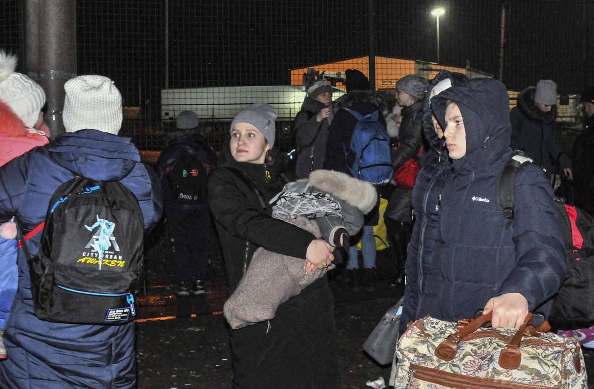 epa09771579 Local residents of the self-proclaimed Donetsk People's Republic wait to entrance Russia at the customs post 'Matveev Kurgan' in Rostov region, Russia, late 18 February 2022 ...