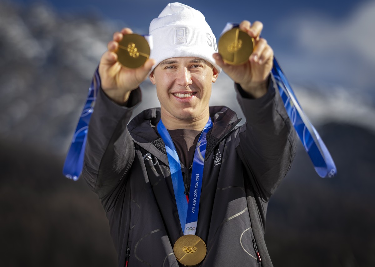 Gold medalist Franjo von Allmen of Switzerland poses for photographers with his three gold medals during a photocall outside the Swiss team hotel at the 2026 Olympic Winter Games at the Stelvio Ski ce ...