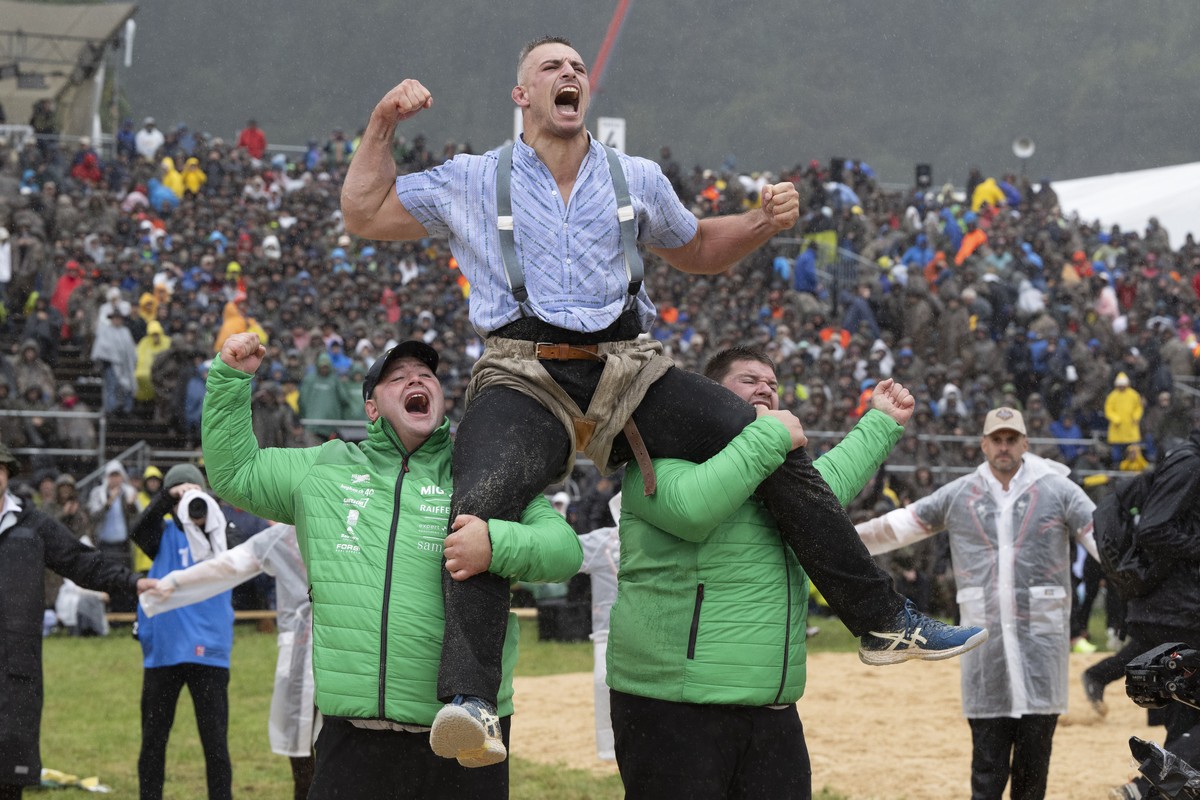 Sieger Sami Giger, oben, wird vom Mario, rechts, und Domenic Schneider geschultert nach dem Schlussgang beim Unspunnen-Schwinget 2023, am Sonntag, 27. August 2023, auf der Hoehenmatte, in Interlaken.  ...