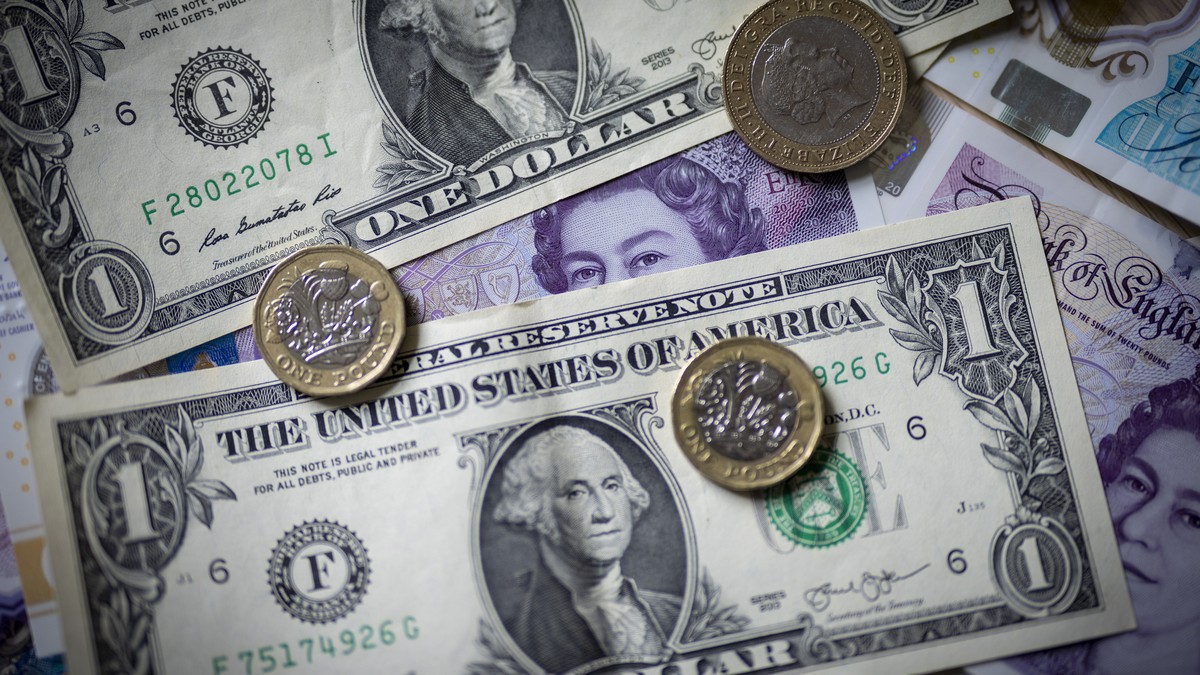 epa10207075 UK and US currencies displayed on a table as the British Pound reaches a record low against the US dollar, in London, Britain, 26 September 2022. The sterling's crash against the doll ...