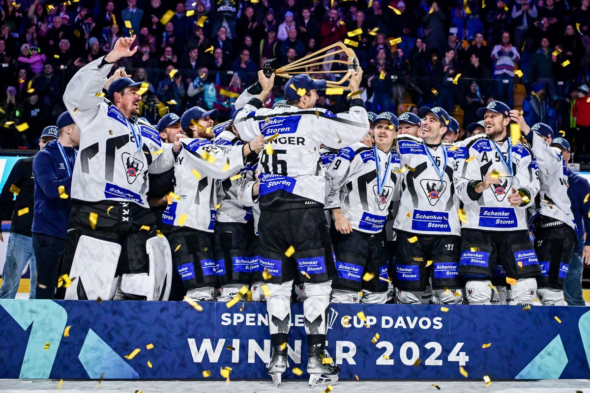 Fribourg's Julien Sprunger and the team celebrate with the prophy after winning the final game between Gerrmany`s Straubing Tigers and Switzerland`s HC Fribourg-Gotteron, at the 96th Spengler Cup ...