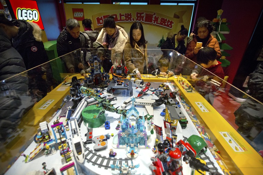 FILE - In this Saturday, Dec. 23, 2017 file photo, people look at a display of Lego creations at Hamleys toy store during its grand opening in Beijing. Toy maker Lego reported Wednesday Feb. 27, 2019, ...