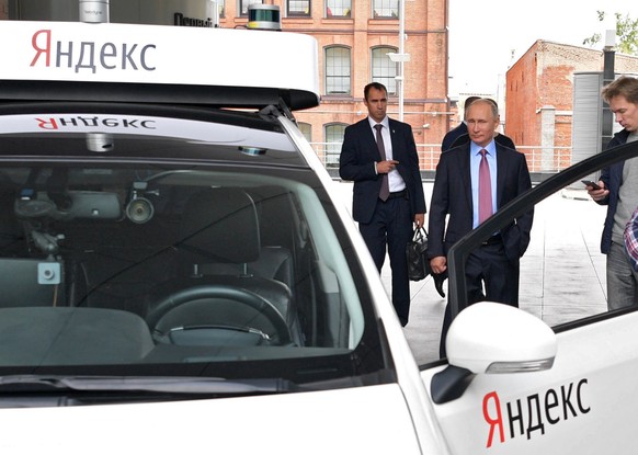 epa06217735 President Vladimir Putin (2-R) attends a demonstration of the prototype of an unmanned car during his visit at Moscow office of the IT company Yandex in Moscow, Russia, 21 September 2017. ...