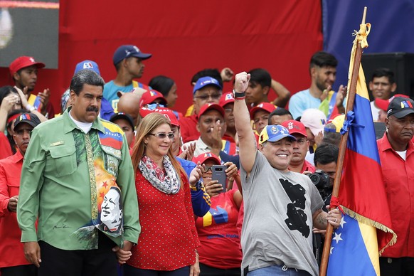 Venezuela&#039;s President Nicolas Maduro, left, holds hands with his his wife, first lady Cilia Flores, as they stand with Argentina&#039;s former soccer player Diego Maradona on stage during Maduro& ...