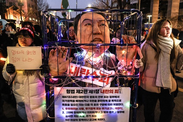 epaselect epa11795750 Protesters walk while displaying a chained effigy depicting impeached South Korean President Yoon Suk Yeol during a rally by civic groups calling for his resignation in Seoul, So ...