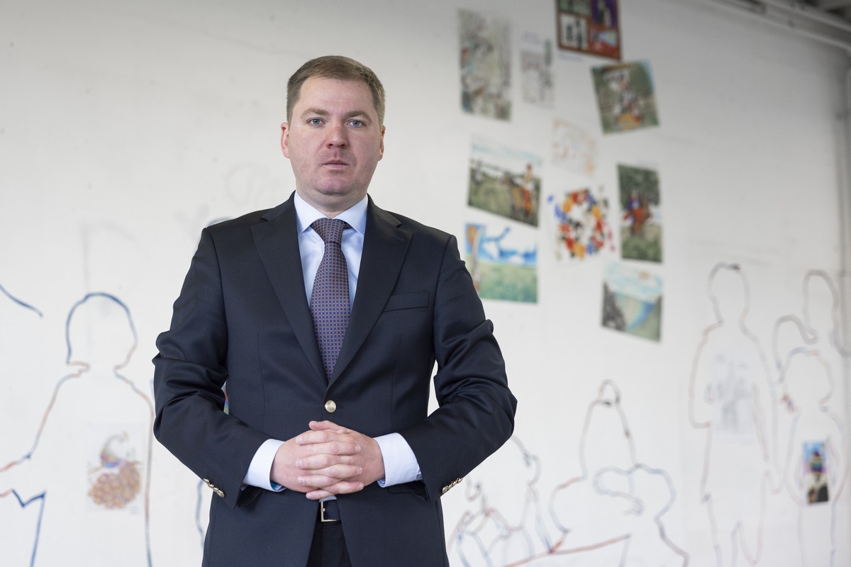 Artem Rybchenko, Ukrainian ambassador to Switzerland, poses for the photographer in front of drawings made by children, during the exhibition "THROUGH THE THORNS..." Art of Ukraine, this Sun ...