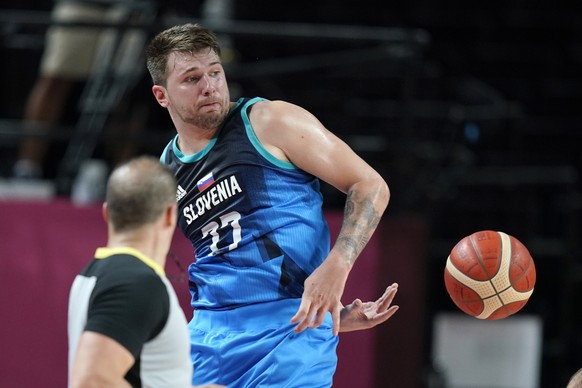 Slovenia&#039;s Luka Doncic saves the ball from going out of bounds during a men&#039;s basketball preliminary round game against Spain at the 2020 Summer Olympics, Sunday, Aug. 1, 2021, in Saitama, J ...