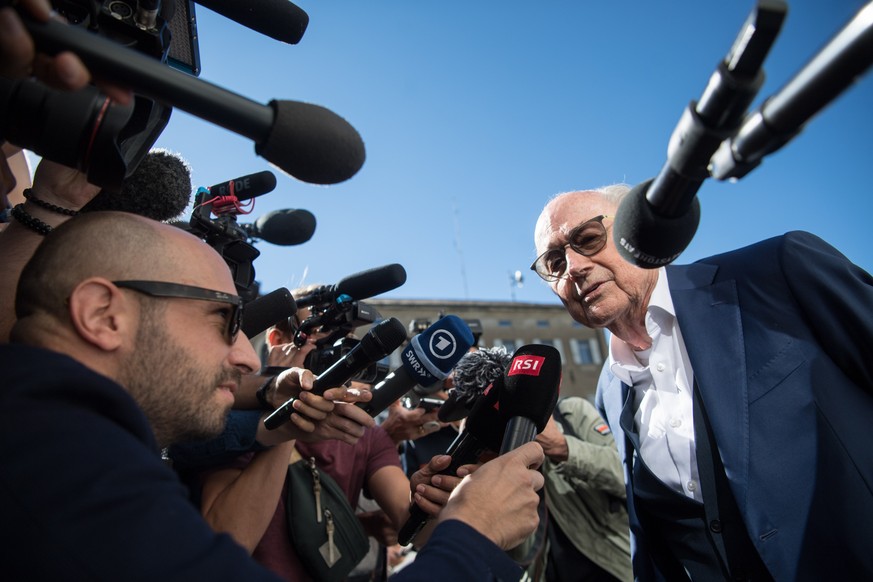 epa10058661 The former president of the World Football Association (FIFA), Joseph Blatter (R), is surrounded by media representatives, as he gives statements at the last day of his trial, when the ver ...