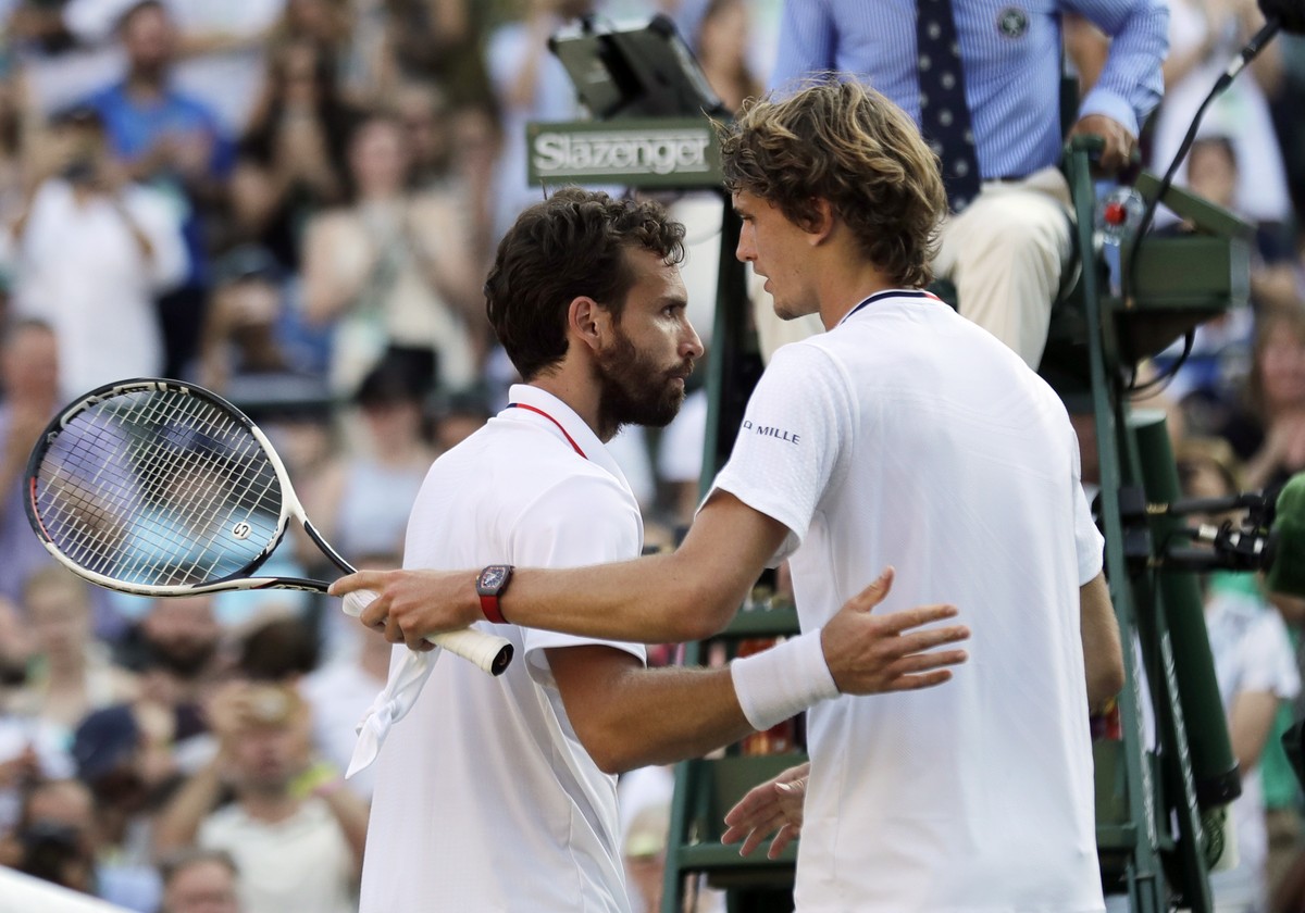 Ernests Gulbis of Latvia, left, meets Alexander Zverev of Germany at the net after defeating him in their men's singles match on the sixth day at the Wimbledon Tennis Championships in London, Sat ...