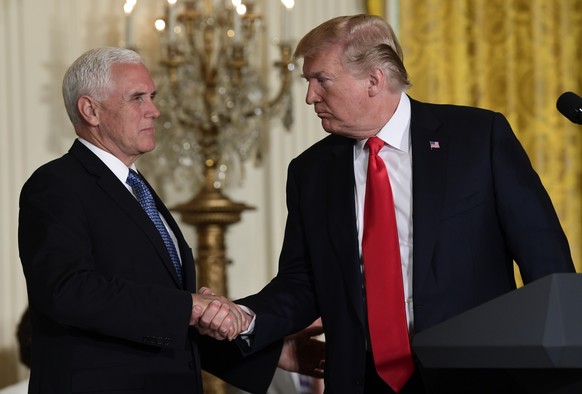 President Donald Trump shakes hands with Vice President Mike Pence during a meeting of the National Space Council in the East Room of the White House, Monday, June 18, 2018, in Washington. (AP Photo/S ...