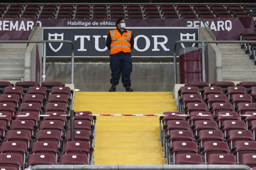 A security officer wearing a face mask as precaution against the spread of the coronavirus COVID-19 guards the grandstand, during the Super League soccer match of Swiss Championship between Servette F ...