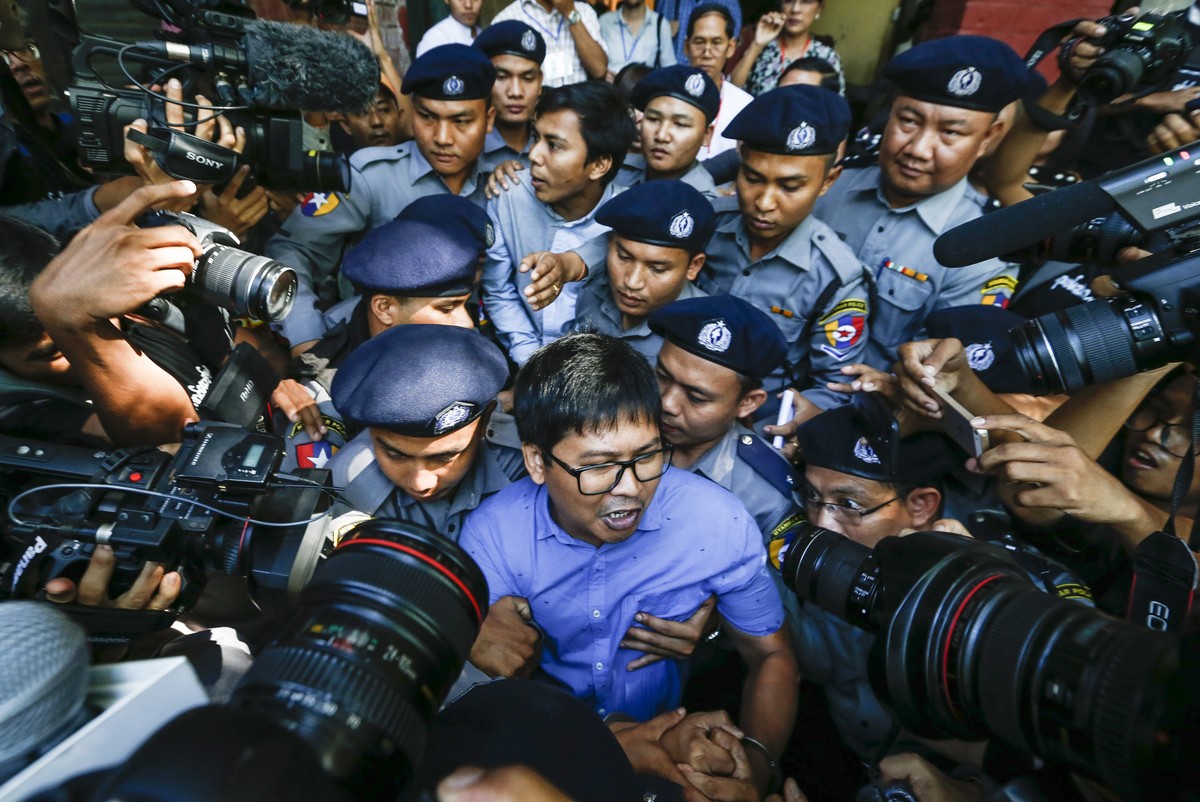 epa07078143 Reuters' journalists Wa Lone (C, front) and Kyaw Soe Oo (C, back) are escorted by police as they leave the court after their first trial in Yangon, Myanmar, 10 January 2018. Reuters j ...