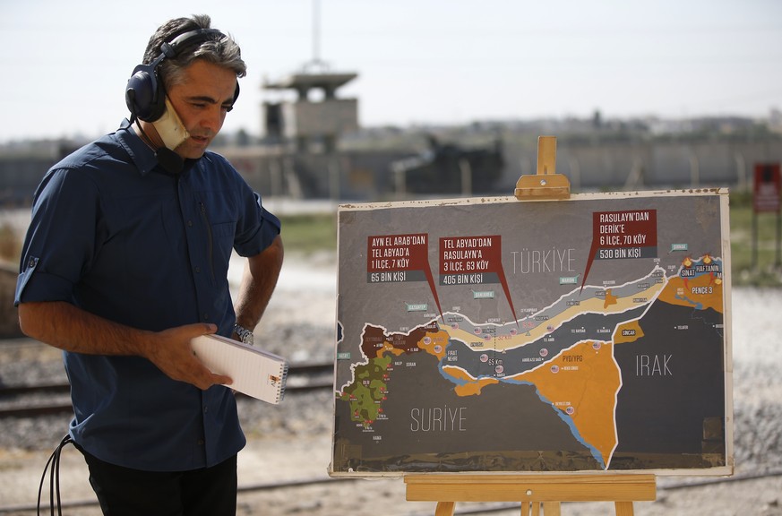 A TV journalist prepares to work in front of a map showing Turkey&#039;s suggested operation in Syria, at the border between Turkey and Syria, in Akcakale, Sanliurfa province, southeastern Turkey, Tue ...