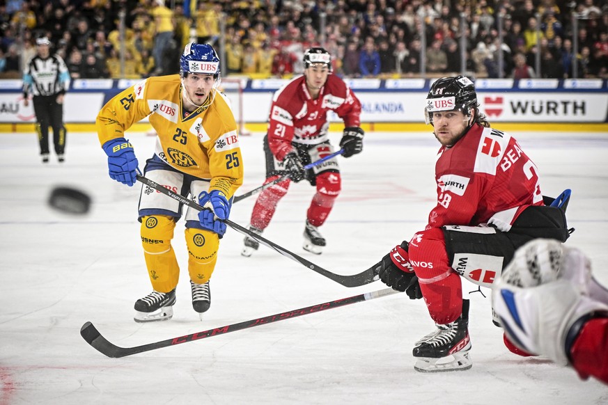 Davos&#039; Henrik Haapala, left, and Canada&#039;s Nathan Beaulieu in action during the game between Team Canada and Switzerland&#039;s HC Davos at the 95th Spengler Cup ice hockey tournament in Davo ...