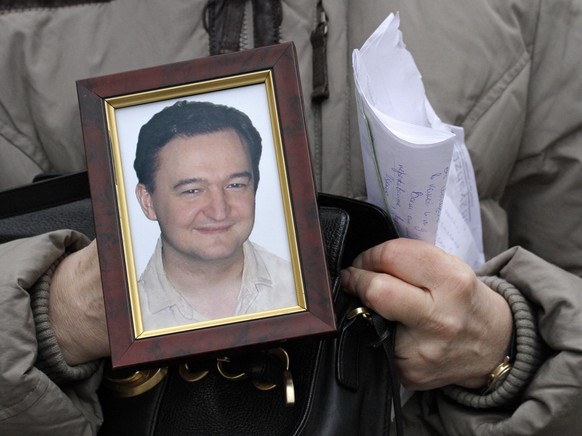 FILE - In this Nov. 30, 2009, file photo a portrait of lawyer Sergei Magnitsky, who died in jail, is held by his mother Nataliya Magnitskaya, as she speaks during an interview with the AP in Moscow. S ...