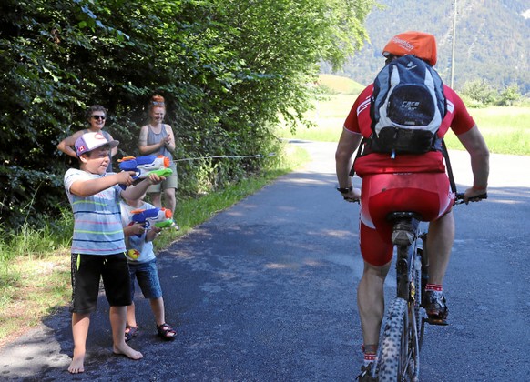 SARNEN, 30JUN19 - Volltreffer. Fuer einmal sind die Biker um eine Abkuehlung aus der Wasserpistole froh. Impression von der Bikestrecke ueber 44 km und 1400 Hoehenmeter von Sarnen via das Grossschlier ...