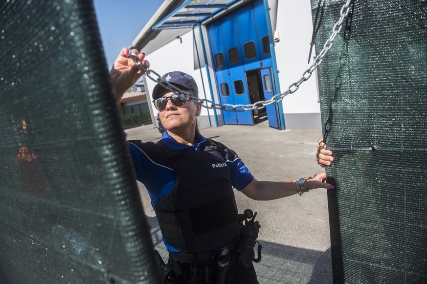 Eine Mitarbeiterin der Kantonspolizei Tessin oeffnet die Tore waehrend einer Medienbesichtigung beim neuen Rueckfuehrungszentrum fuer Migranten am Mittwoch, 24. August 2016, in Mendrisio-Rancate, Tess ...