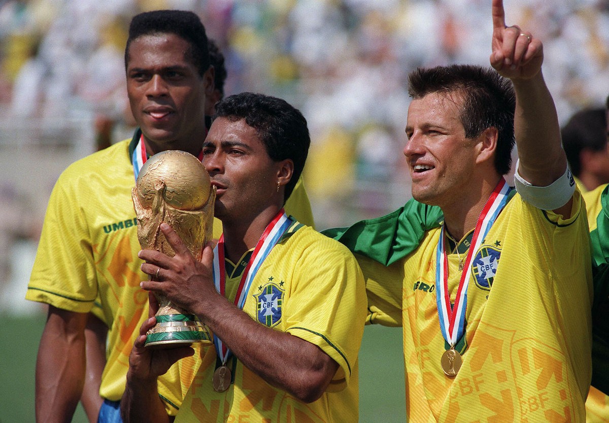 Brazilian forward Romario kisses the FIFA World Cup trophy, flanked by Ronaldao (L) and captain Dunga, after Brazil defeated Italy 3-2 in the shoot-out session at the end of the World Cup final, 17 Ju ...