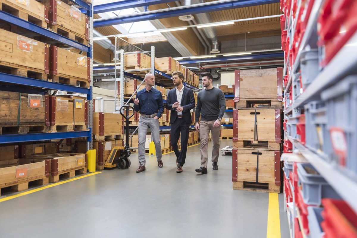 Three men walking and talking in factory storeroom model released Symbolfoto property released PUBLICATIONxINxGERxSUIxAUTxHUNxONLY DIGF03848