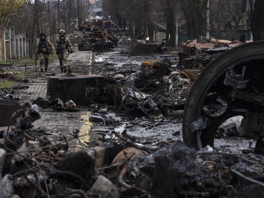 Ukrainische Soldaten gehen auf einer Strasse, die übersät ist mit den Trümmern von russischen Panzern, Butscha, 03. April 2022.<br><a target="_blank" rel="nofollow" href="https://rodrigoabd.com/">Rodrigo Abd</a> ist ein argentinischer Fotojournalist, der seit 2003 für die Nachrichtenagentur The Associated Press (<a target="_blank" rel="nofollow" href="https://apnews.com/">AP</a>) arbeitet. Er hat unter anderem den Krieg in Afghanistan dokumentiert. 