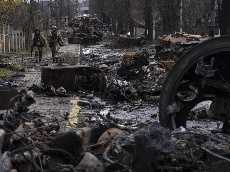 Soldiers walk amid destroyed Russian tanks in Bucha, on the outskirts of Kyiv, Ukraine, Sunday, April 3, 2022. (AP Photo/Rodrigo Abd)