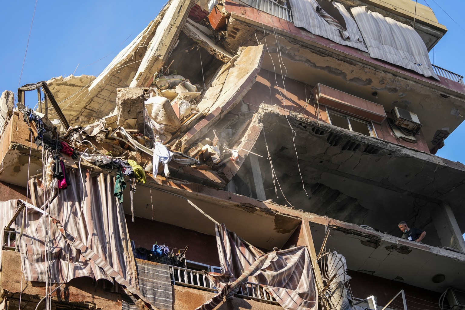 Residents check a partially destroyed building at the site of an Israeli airstrike in Beirut&#039;s southern suburbs, Tuesday, Sept. 24, 2024. (AP Photo/Hassan Ammar)