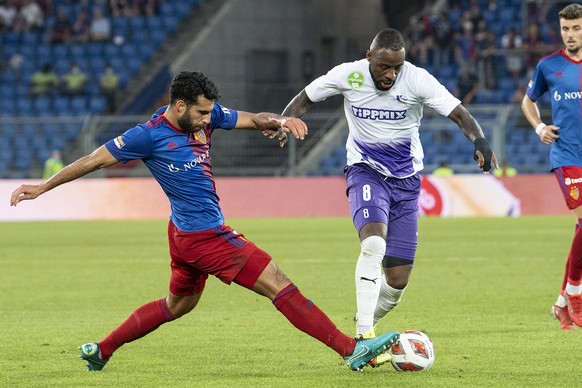 epa09411559 Basel's Eray Coemert (L) in action against Budapest's Junior Tallo during the UEFA Conference League third qualifying round second leg soccer match between FC Basel and Ujpest Budapest at the St. Jakob Park stadium in Basel, Switzerland, 12 August 2021.  EPA/PETER SCHNEIDER