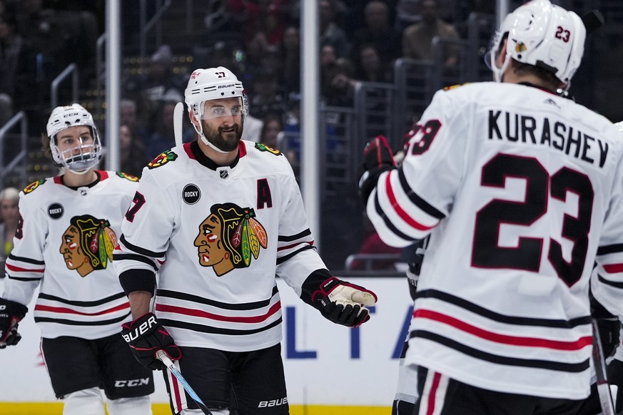 Chicago Blackhawks left wing Nick Foligno, center, celebrates his goal against the Los Angeles Kings with center Philipp Kurashev, right, during the first period of an NHL hockey game Tuesday, March 1 ...