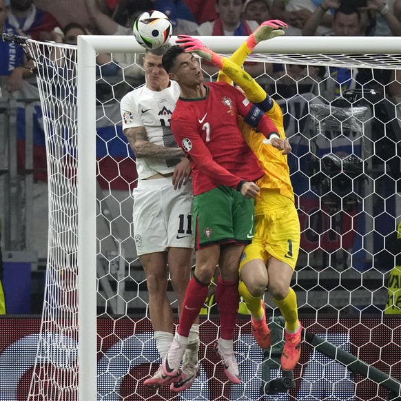 From left, Slovenia&#039;s Benjamin Sesko, Portugal&#039;s Cristiano Ronaldo and Slovenia&#039;s goalkeeper Jan Oblak fight for the ball during a round of sixteen match between Portugal and Slovenia a ...
