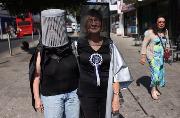 epa13157150 Political campaigners dressed in capes and bins give out leaflets in support of Count Binface in Clacton-on-Sea (Clacton), Britain, 08 August 2026. Reform UK leader Nigel Farage will conte ...