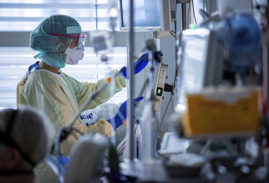 Nurse Franziska Strauss documents the treatment steps next to the bed of a Covid-19 patient at the intensive care unit of the University Hospital in Greifswald . Covid-19 patients have been treated at ...