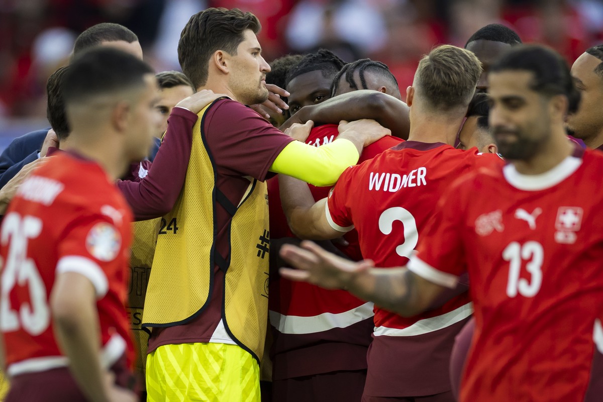 Switzerland's Manuel Akanji, center, is hugged by his teammates after losing the penalty shoot-out of the quarter final match between England and Switzerland at the Euro 2024 soccer tournament in ...