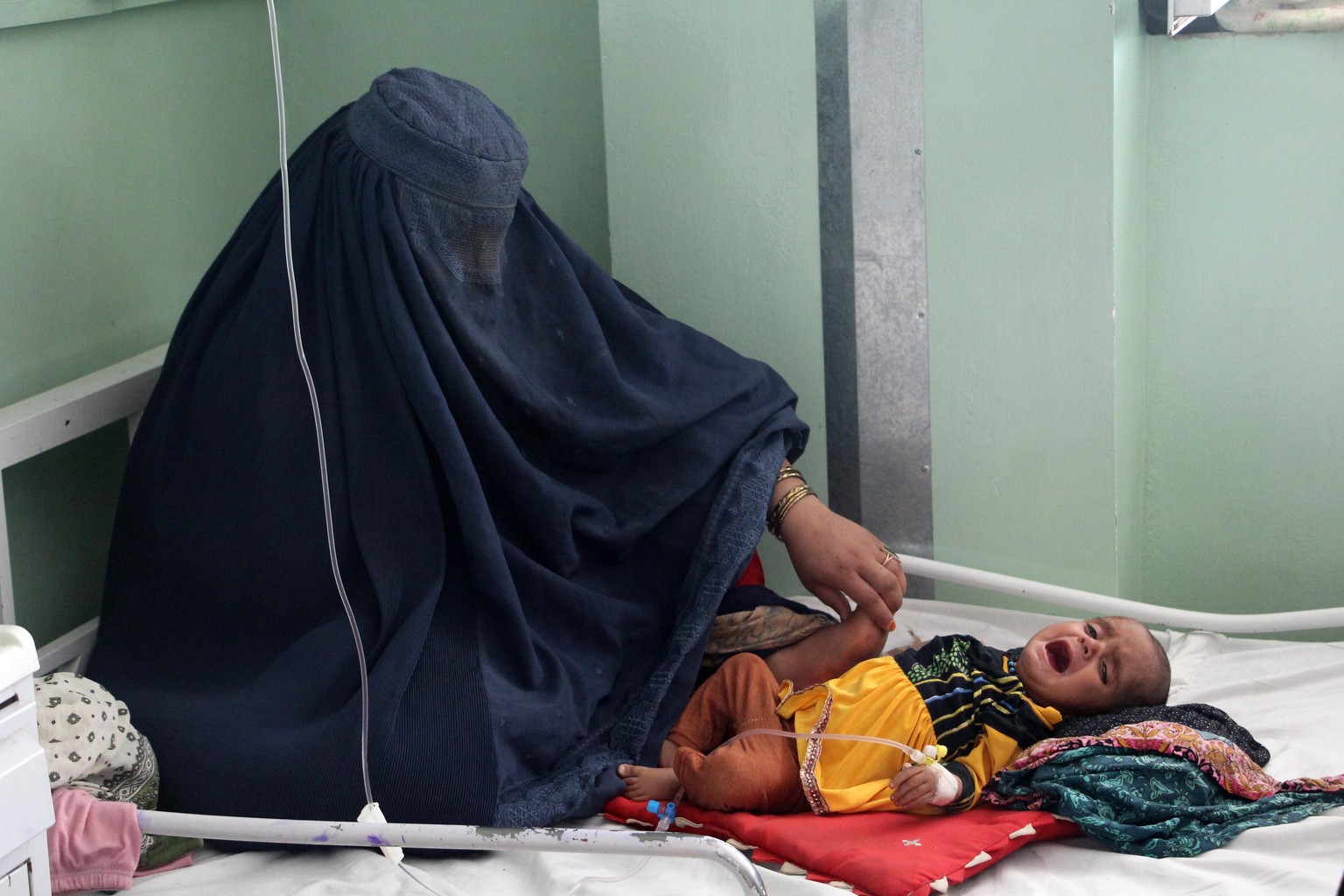epa10647720 An Afghan woman sits next to child suffering from malnutrition and other diseases while receiving treatment at Mirwais hospital in Kandahar, Afghanistan, 23 May 2023. Some 2.3 million chil ...