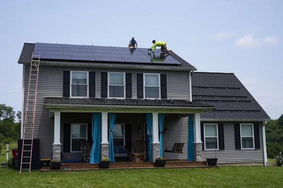 Brian Hoeppner, left, and Nicholas Hartnett, owner of Pure Power Solar, install a solar panel on the roof of a home in Frankfort, Ky., Monday, July 17, 2023. Since passage of the Inflation Reduction A ...