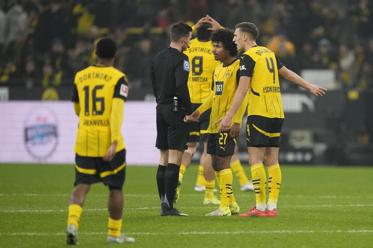 Dortmund's Karim Adeyemi, second right, argues with the referee after receiving a yellow card during the German Bundesliga soccer match between Borussia Dortmund and TSG Hoffenheim at the Signal- ...