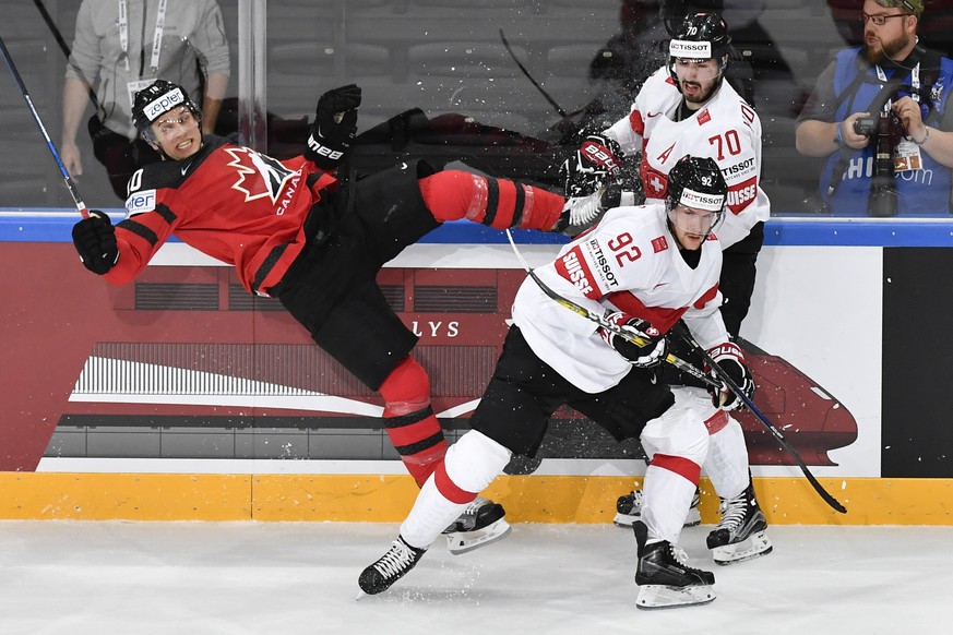 Switzerland’s Gaeetan Haas, center, and Switzerland’s Denis Hollenstein, right, in action against Canada’s Brayden Schenn during their Ice Hockey World Championship group B preliminary round match bet ...