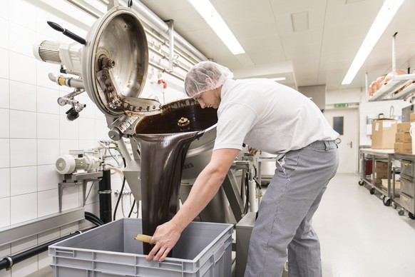 ZUM SCHWEIZER SCHOKOLADE PRODUZENTEN LAEDERACH STELLEN WIR IHNEN HEUTE UNSER NEUES BILDMATERIAL ZUR VERFUEGUNG --- Die fertig gemischte Schokoladenmasse wird fuer die Weiterverarbeitung in einen fahrb ...