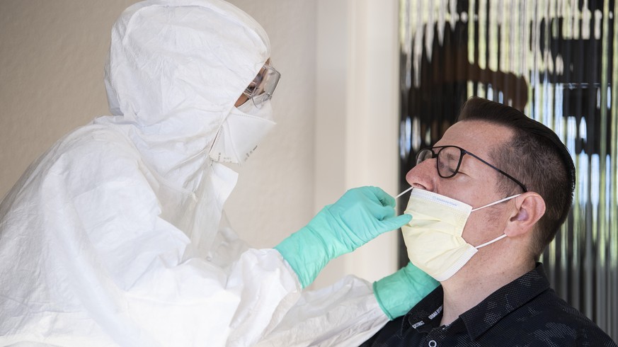 Fiona Furrer vom Medizinischen Fachpersonal, und Patient Stephan Kilcher zeigen wie man Patientinnen und Patienten mit Verdacht auf den Coronavirus einen COVID-19-Abstrich in deren haeuslicher Umgebun ...