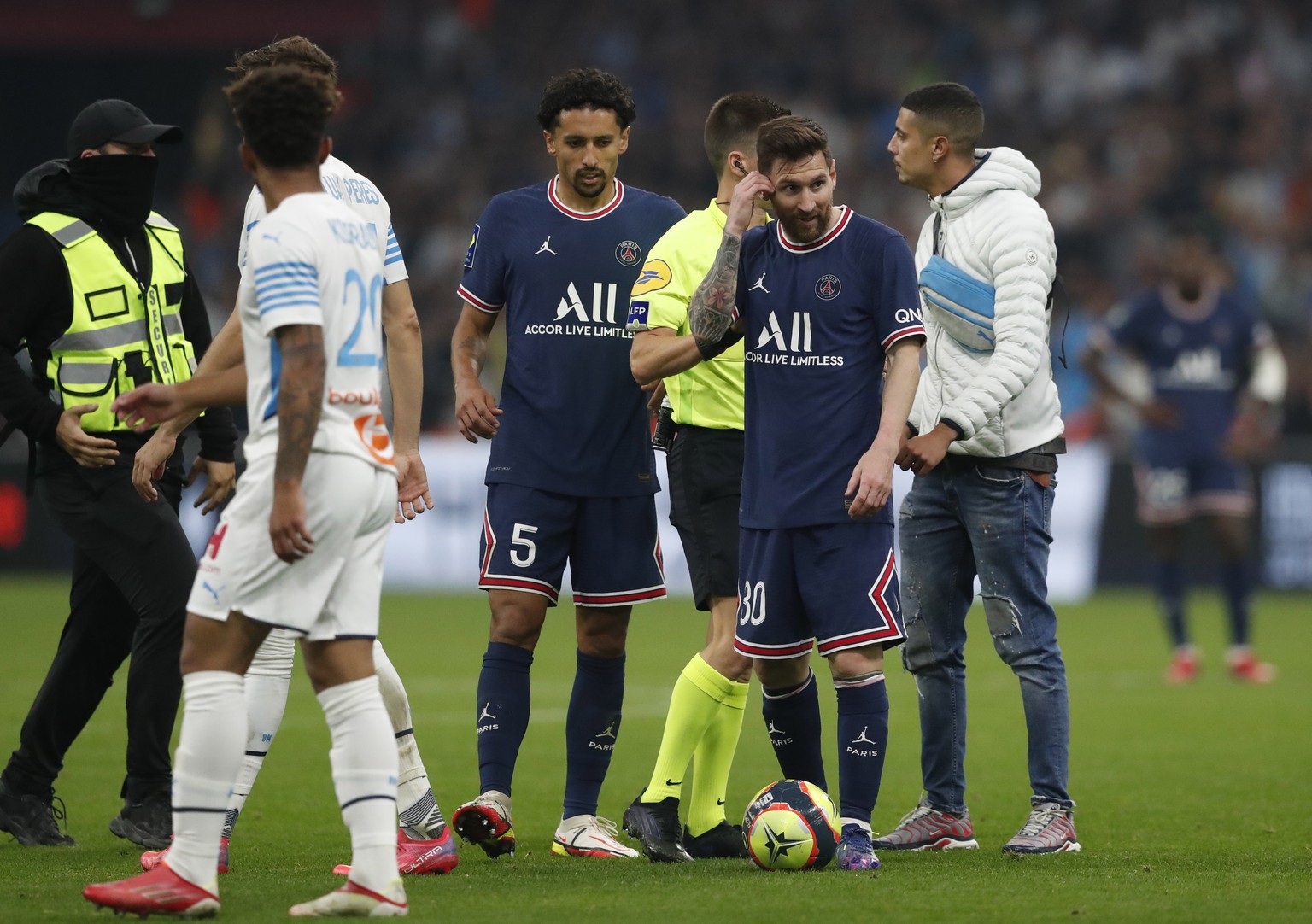 epa09544495 A fan (R) invaded the pitch to speak with Lionel Messi (L) of Paris Saint Germain in action during the French Ligue 1 soccer match between Olympique Marseille and Paris Saint Germain at th ...