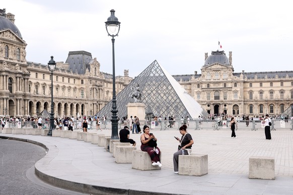 epa13119373 People enjoy the surrondings of the Louvre Museum in Paris, France, 18 July 2026. EPA/TERESA SUAREZ