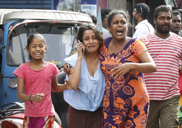 epa07521268 Sri Lankan people run for safety as authorities announced an evacuation of the area after a van was found parked with a suspected explosive device near St Anthony&#039;s Church Kochchikade ...