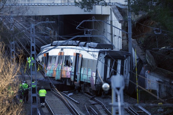 epa12673763 Workers at the site where a commuter train derailed after a restraining wall broke just as it was passing in Gelida, Catalonia, Spain, 23 January 2026. A commuter train was hit on 20 Janua ...