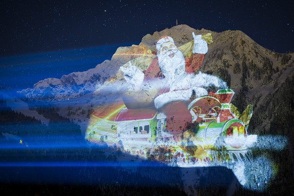 epa11014344 An image of Santa Claus is projected on the Rochers-de-Naye mountain on the sidelines of the Montreux Christmas market, in Haut de Caux near Montreux, Switzerland, 06 December 2023. The fi ...
