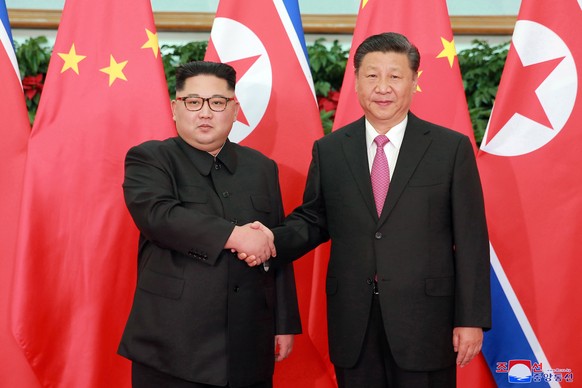 epa06720745 A photo released by the official North Korean Central News Agency (KCNA), the state news agency of North Korea, shows North Korean leader Kim Jong-un (L) shaking hands with Chinese Preside ...